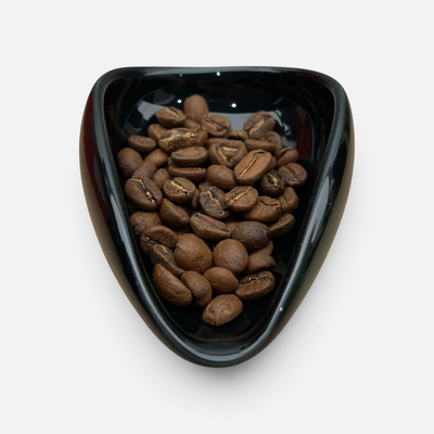 Nærbilde av kaffebønner i porselenskål rett før bruk av ross droplet technique med doseringssett for kaffebønner.