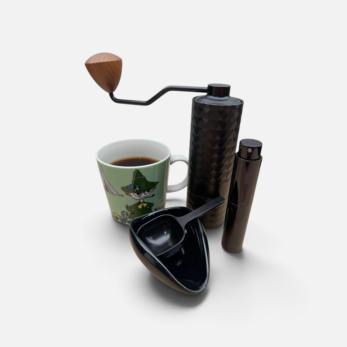 Doseringssettet sammen med en kaffekvern og en kaffekopp for å illustrere settet i bruk.