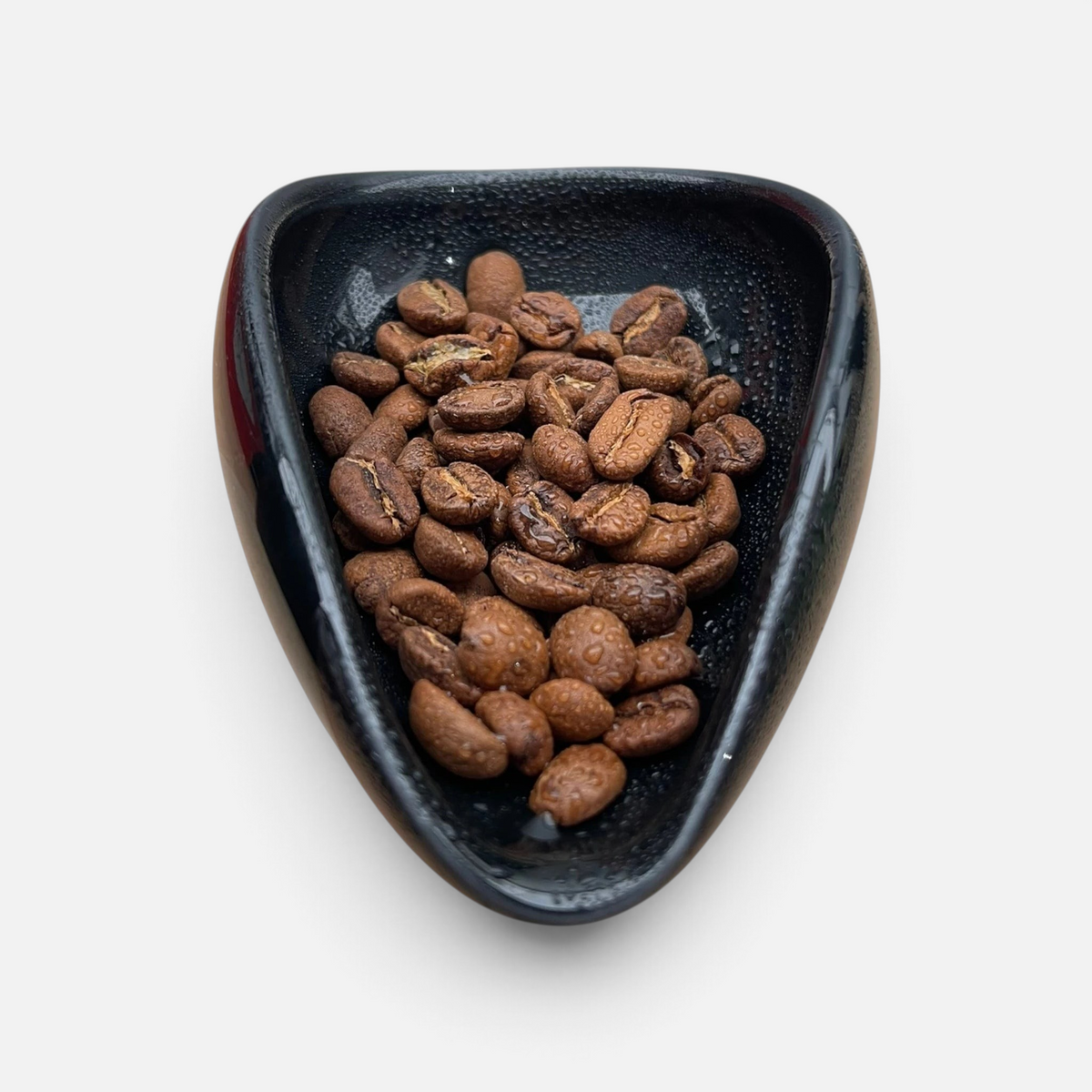 Nærbilde av kaffebønner i porselenskål rett etter bruk av ross droplet technique med doseringssett for kaffebønner.